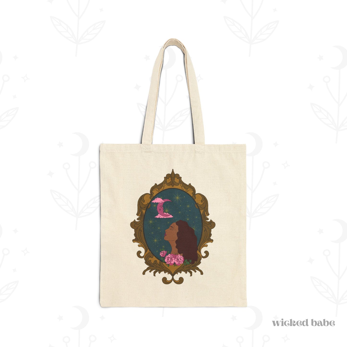 Canvas tote bag with design of a tan skinned woman with red brown wavy hair with pink flowers and a pink crescent moon above on a teal background surrounded by an ornate gold frame