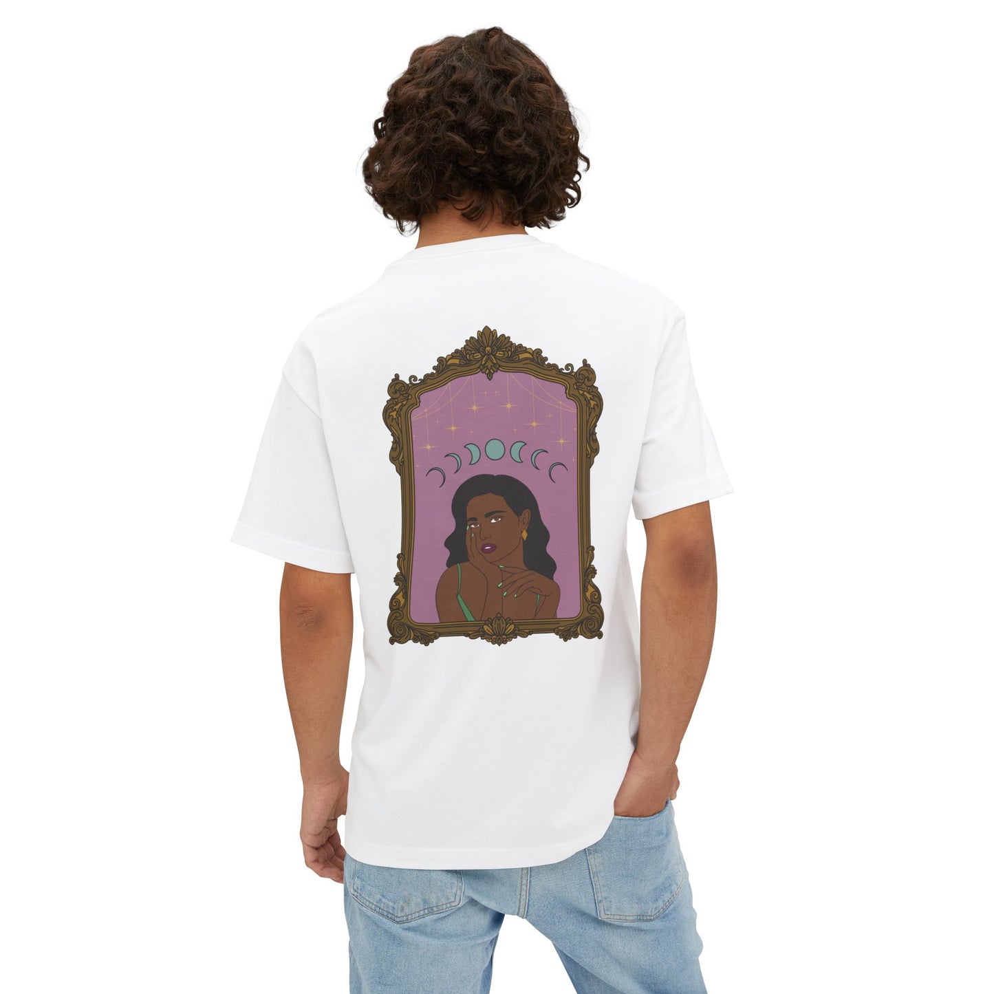 Man wearing an oversized short sleeve white t-shirt with design of a dark skinned woman with black hair wearing green on a pink background with moon phases above surrounded by ornate gold frame on the back