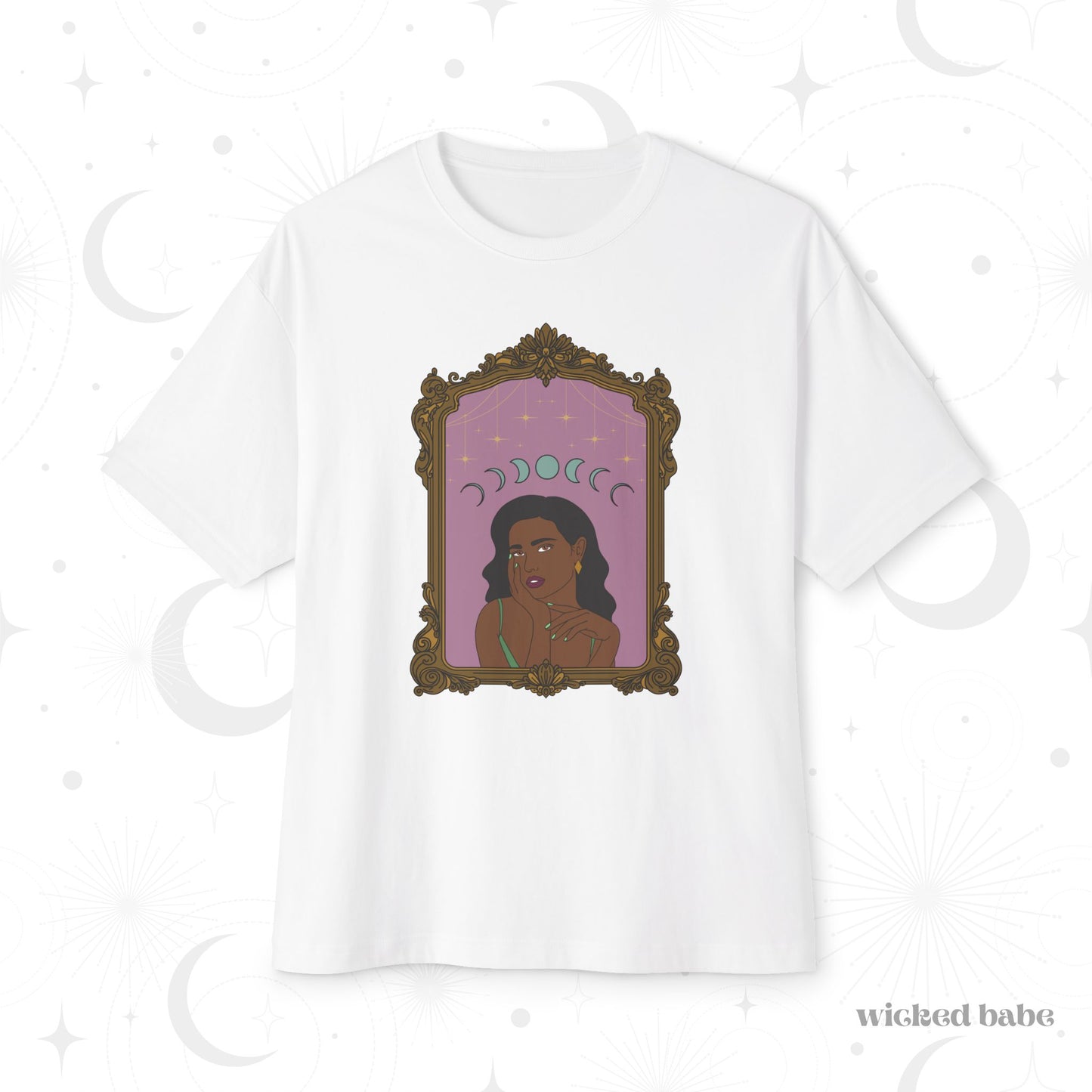 Oversized short sleeve white t-shirt with design of a dark skinned woman with black hair wearing green on a pink background with moon phases above surrounded by ornate gold frame