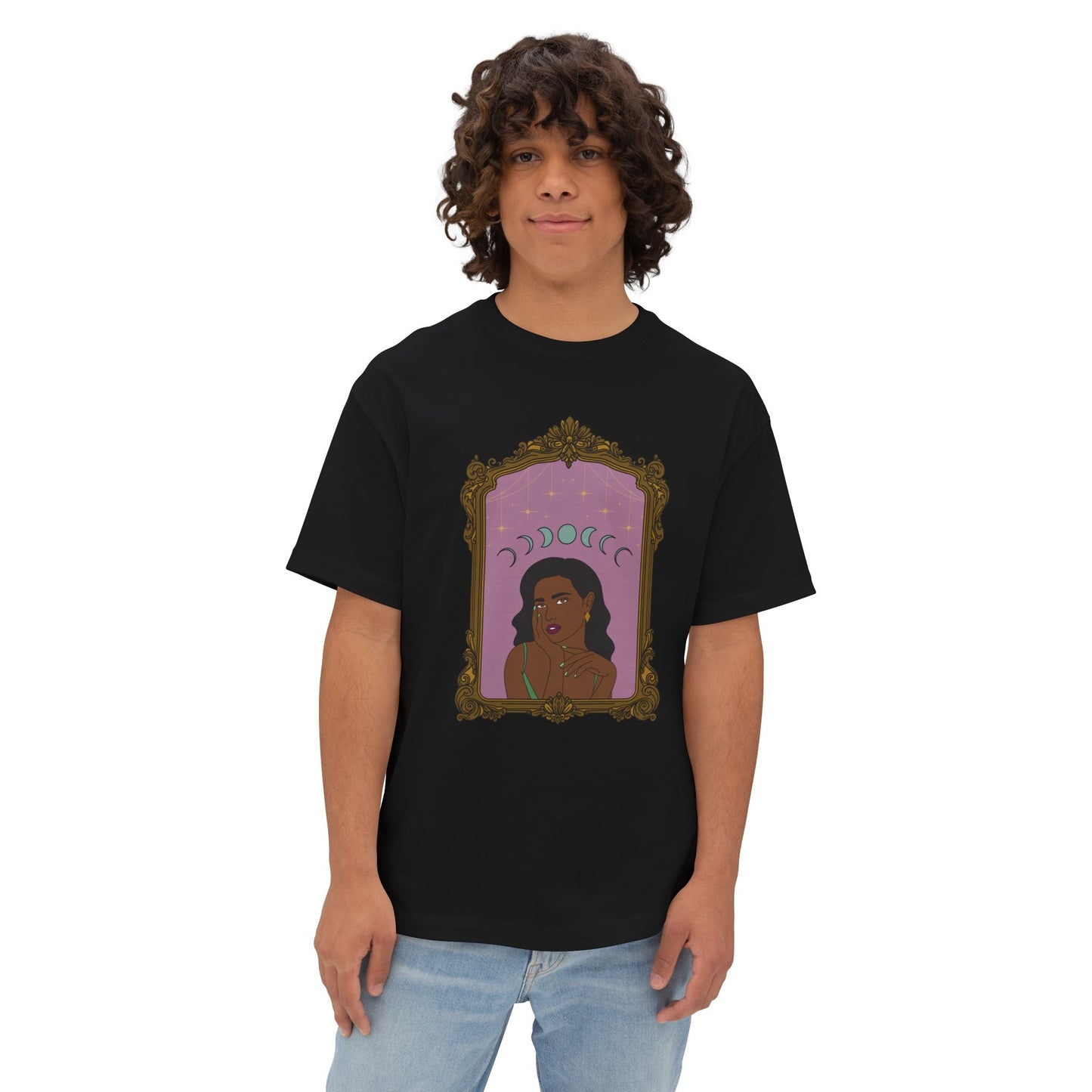 Man wearing an oversized short sleeve black t-shirt with design of a dark skinned woman with black hair wearing green on a pink background with moon phases above surrounded by ornate gold frame
