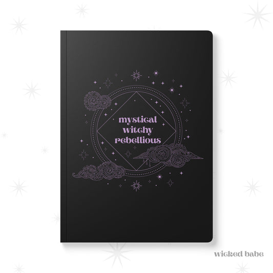 Black softcover journal notebook with mystical witchy rebellious text in purple surrounded by clouds and stars