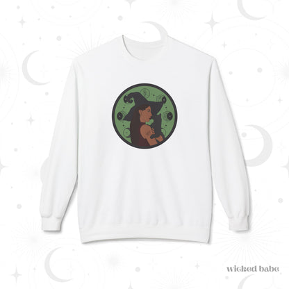 White crewneck long sleeve pullover sweatshirt featuring a design of a woman wearing a witch's hat holding a gray cat with moon phases on a green background