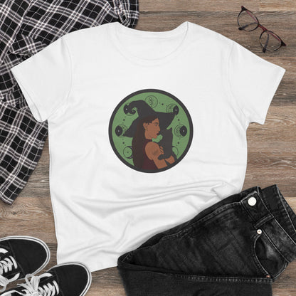 White short sleeve crew neck t-shirt featuring a design of a woman wearing a witch's hat holding a gray cat with moon phases on a green background, displayed as a flatlay with jeans and sneakers