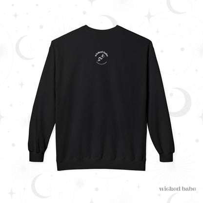 The back of a black long sleeve crewneck sweatshirt with a small white wicked babe hand with serpent logo in the upper center