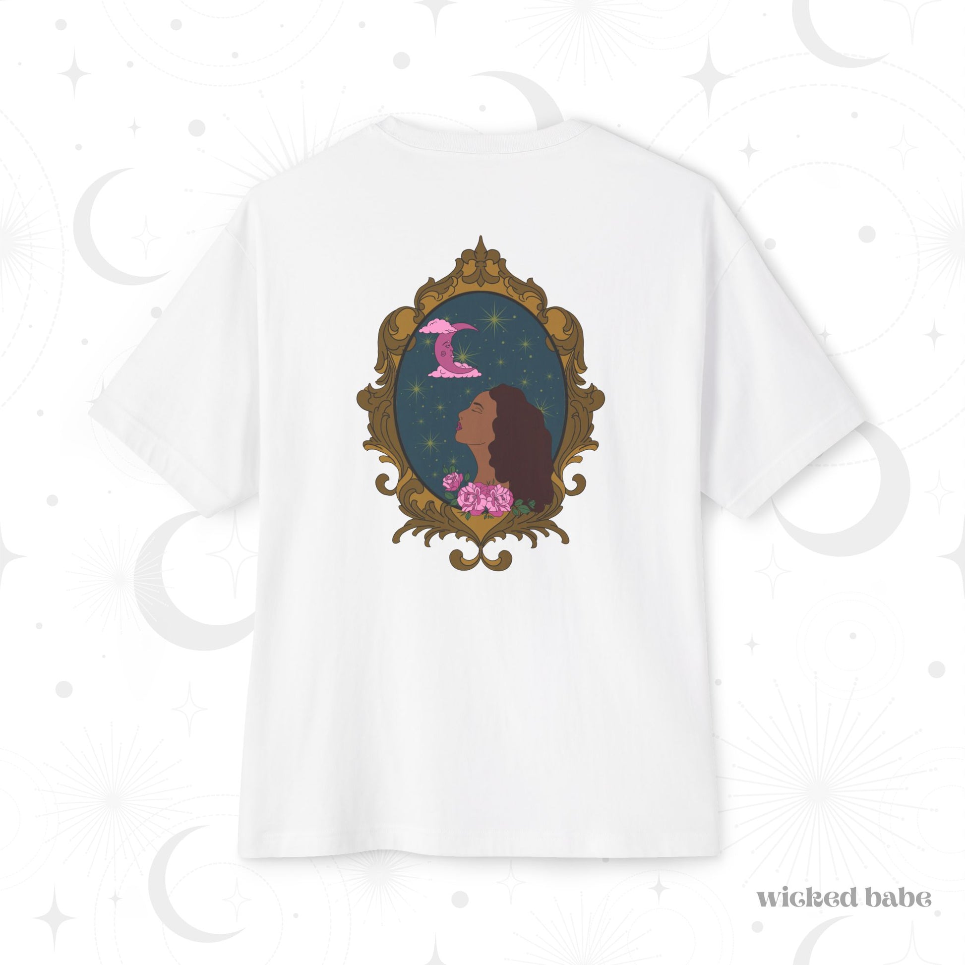 Oversized short sleeve white t-shirt with a design of a tan skinned woman with red brown wavy hair with pink flowers and a pink crescent moon above on a teal background surrounded by an ornate gold frame on the back