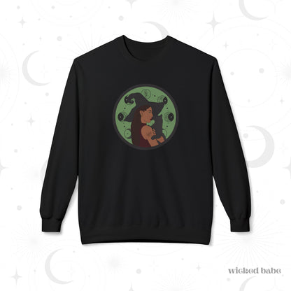 Black crewneck long sleeve pullover sweatshirt featuring a design of a woman wearing a witch's hat holding a gray cat with moon phases on a green background