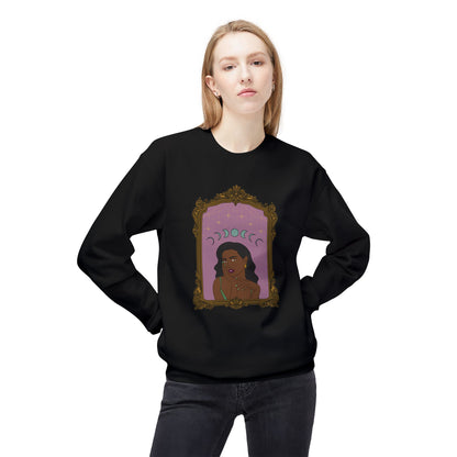 Woman wearing a black long sleeve crewneck sweatshirt with design of a dark skinned woman with black hair wearing green on a pink background with moon phases above surrounded by ornate gold frame