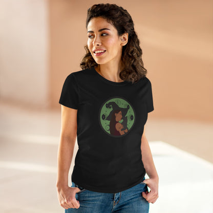 Woman wearing a black short sleeve crew neck t-shirt featuring a design of a woman wearing a witch's hat holding a gray cat with moon phases on a green background