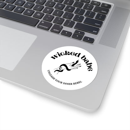3 inch white circular sticker with 'wicked babe' hand with serpent logo in black on a laptop