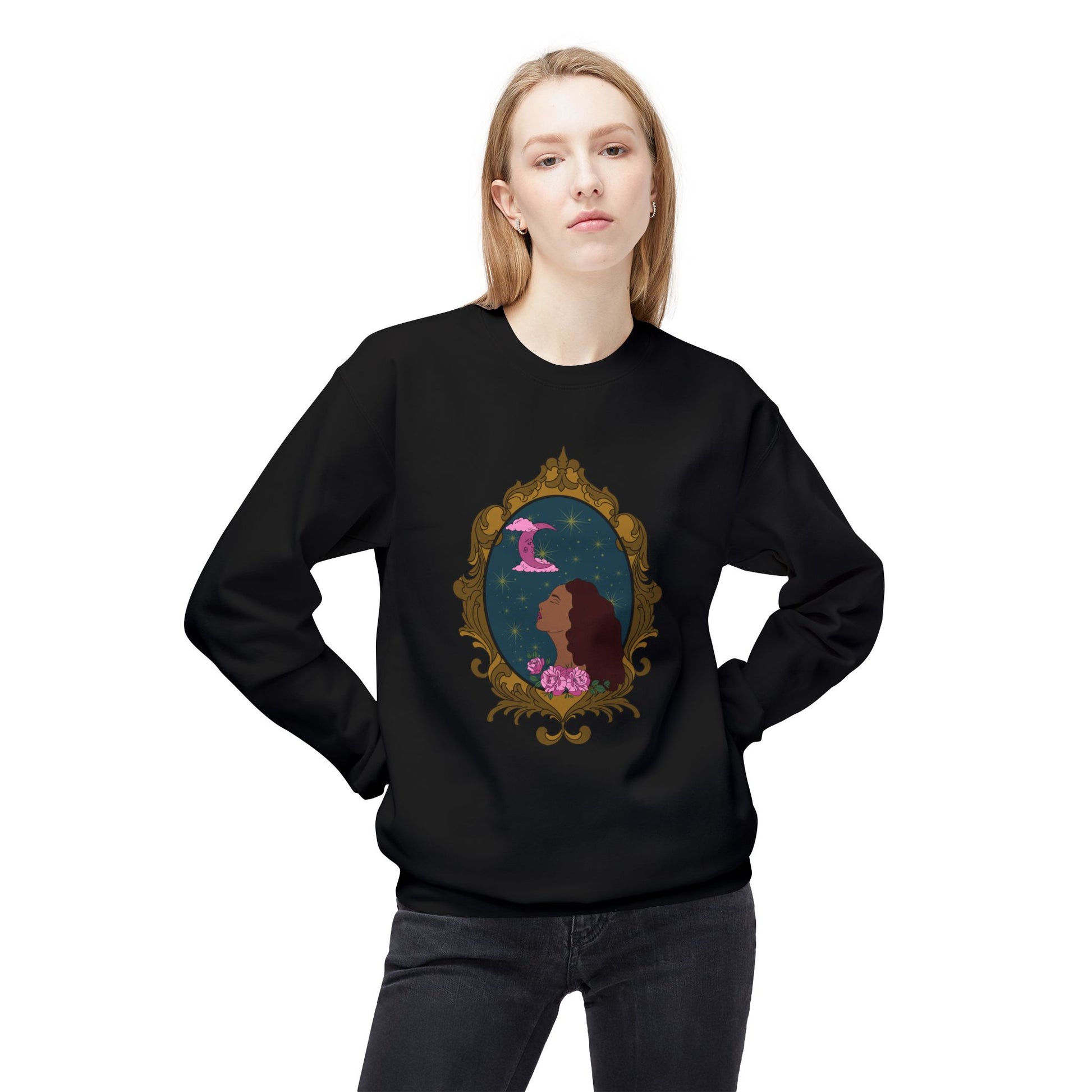 Woman wearing a black long sleeve crewneck sweatshirt with design of a tan skinned woman with red brown wavy hair with pink flowers and a pink crescent moon above on a teal background surrounded by an ornate gold frame