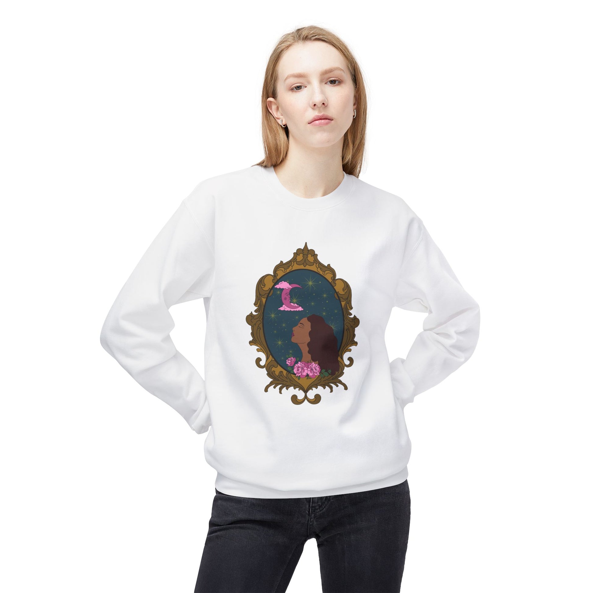 Woman wearing a white long sleeve crewneck sweatshirt with design of a tan skinned woman with red brown wavy hair with pink flowers and a pink crescent moon above on a teal background surrounded by an ornate gold frame