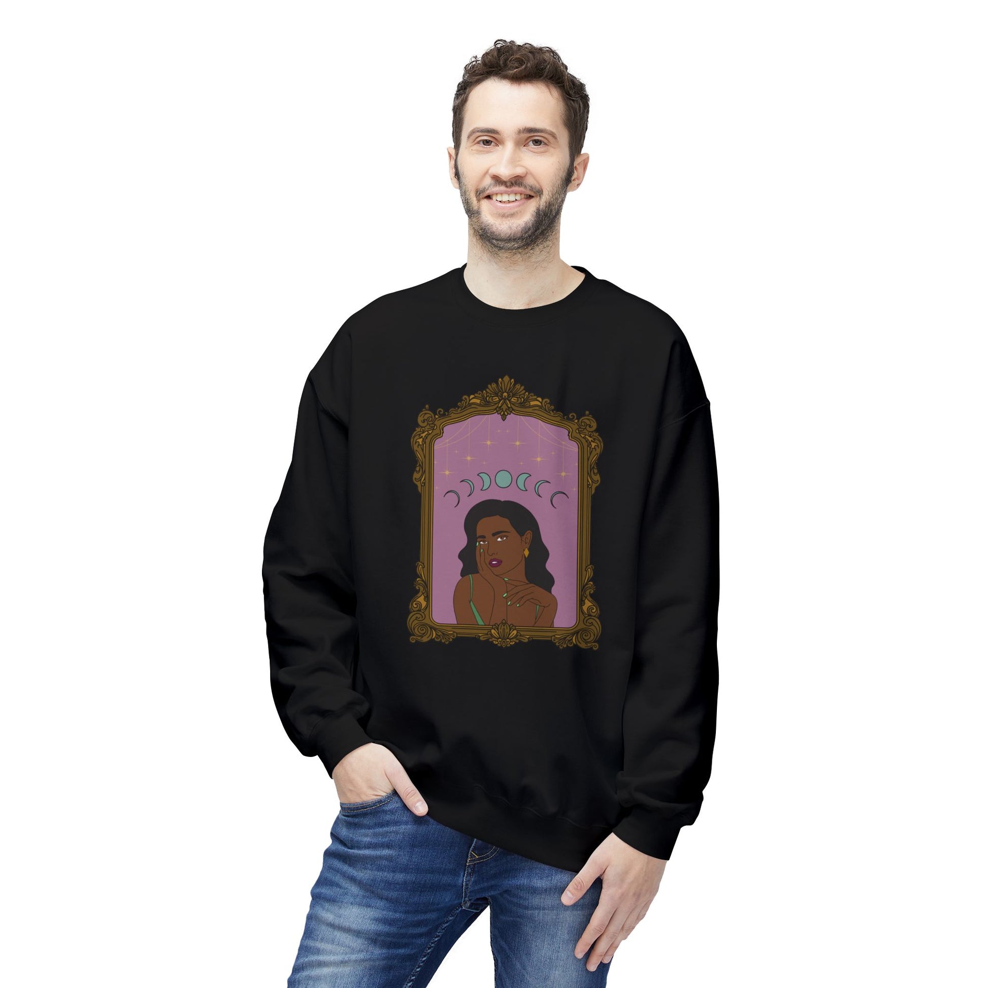 Man wearing a black long sleeve crewneck sweatshirt with design of a dark skinned woman with black hair wearing green on a pink background with moon phases above surrounded by ornate gold frame