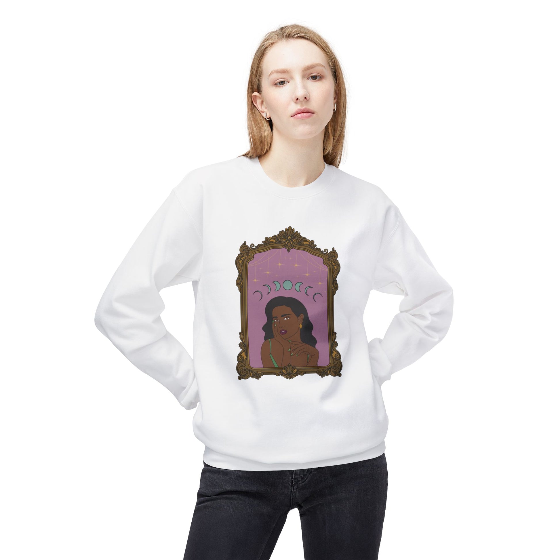 Woman wearing a white long sleeve crewneck sweatshirt with design of a dark skinned woman with black hair wearing green on a pink background with moon phases above surrounded by ornate gold frame