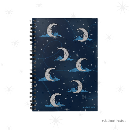 Front of a spiral hardcover notebook with blue celestial sky with silver crescent moon and stars