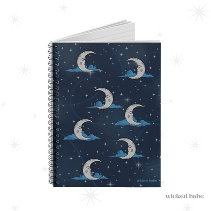 Slightly opened spiral hardcover notebook with blue celestial sky with silver crescent moon and stars