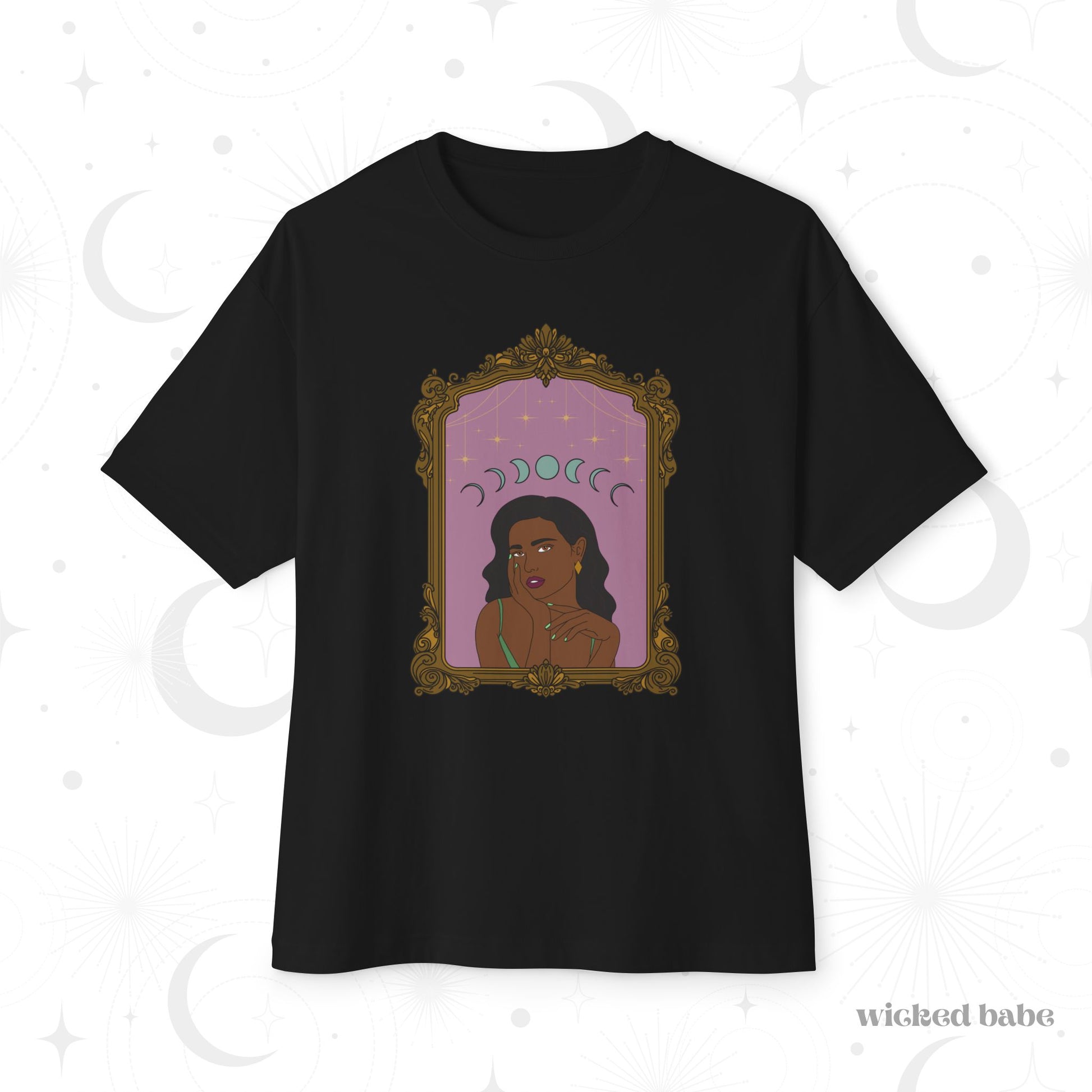 Oversized short sleeve black t-shirt with design of a dark skinned woman with black hair wearing green on a pink background with moon phases above surrounded by ornate gold frame
