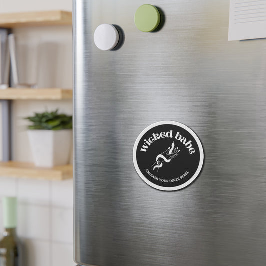 Charcoal circular refrigerator magnet with 'wicked babe' hand with serpent logo in white with a white border on a stainless steel fridge