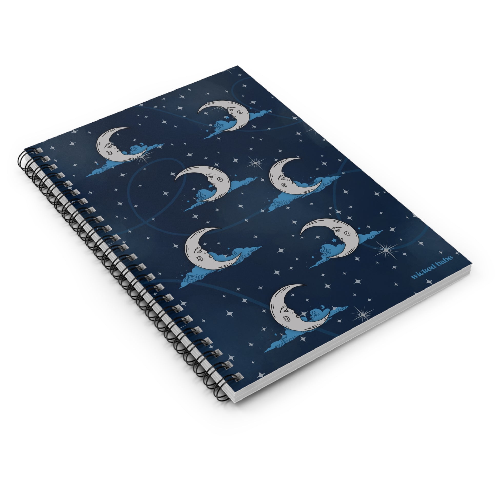 Flatlay of spiral hardcover notebook with blue celestial sky with silver crescent moon and stars