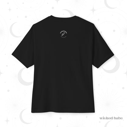 The back of an oversized short sleeve black t-shirt with small white wicked babe hand with serpent logo in the upper center