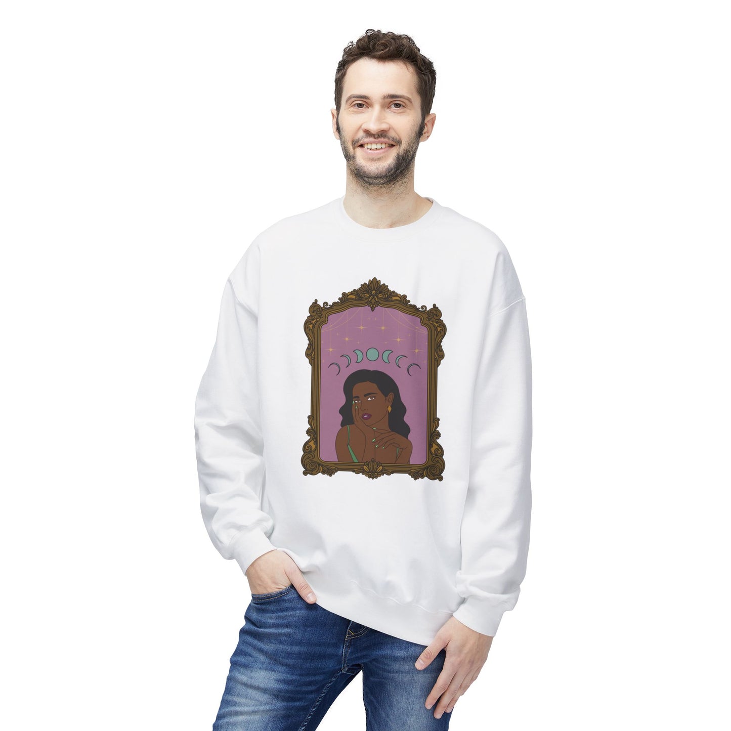 Man wearing a white long sleeve crewneck sweatshirt with design of a dark skinned woman with black hair wearing green on a pink background with moon phases above surrounded by ornate gold frame