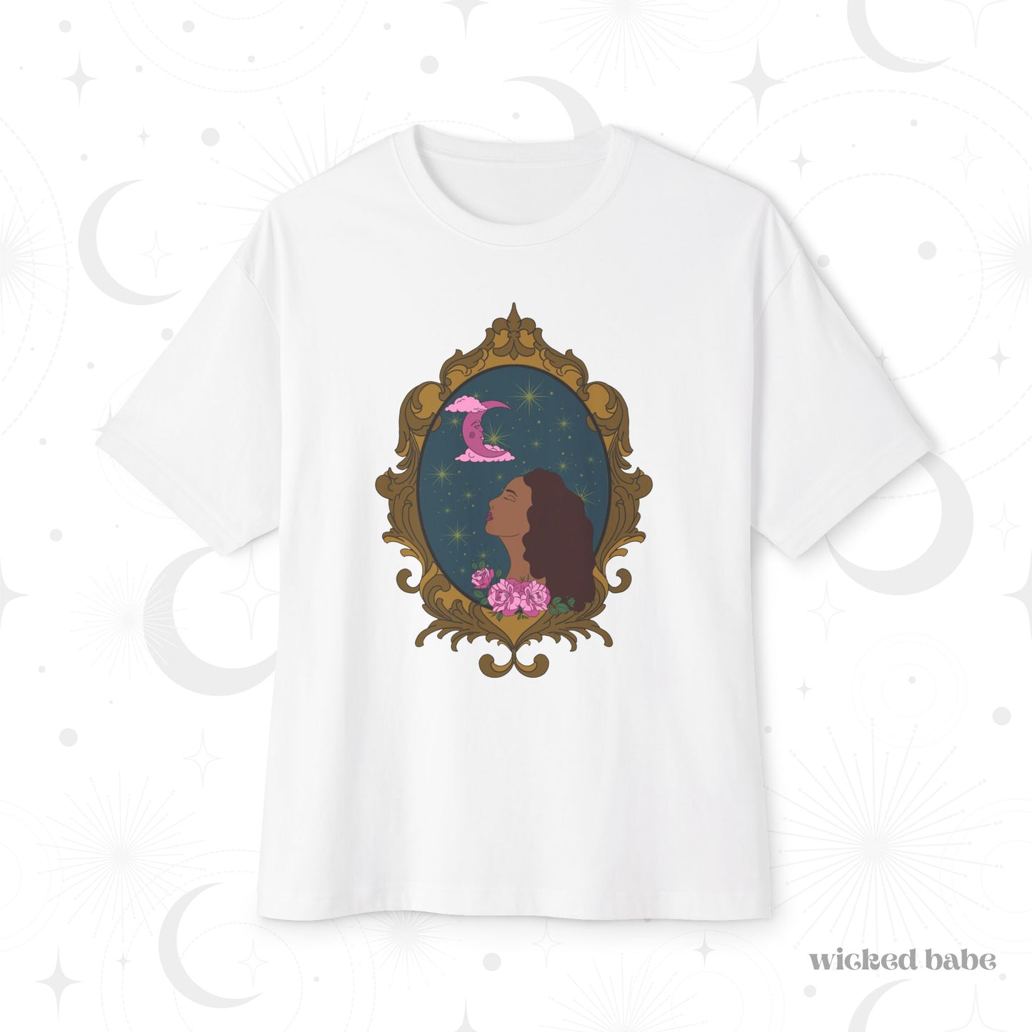 Oversized short sleeve white t-shirt with a design of a tan skinned woman with red brown wavy hair with pink flowers and a pink crescent moon above on a teal background surrounded by an ornate gold frame
