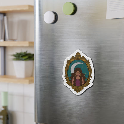 Refrigerator magnet with design of a tan skinned woman with brown wavy hair wearing purple in front of large crescent moon on a teal background surrounded by ornate gold frame with a white border on a stainless steel fridge