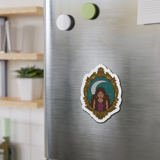 Refrigerator magnet with design of a tan skinned woman with brown wavy hair wearing purple in front of large crescent moon on a teal background surrounded by ornate gold frame with a white border on a stainless steel fridge