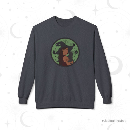 Dark heather gray crewneck long sleeve pullover sweatshirt featuring a design of a woman wearing a witch's hat holding a gray cat with moon phases on a green background
