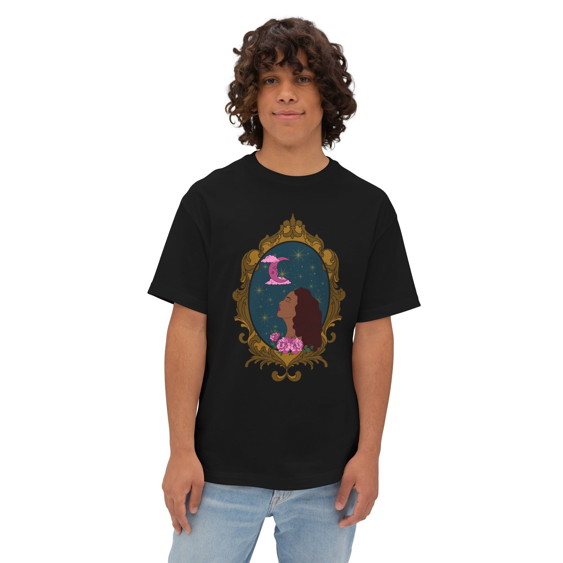 Man wearing an oversized short sleeve black t-shirt with a design of a tan skinned woman with red brown wavy hair with pink flowers and a pink crescent moon above on a teal background surrounded by an ornate gold frame