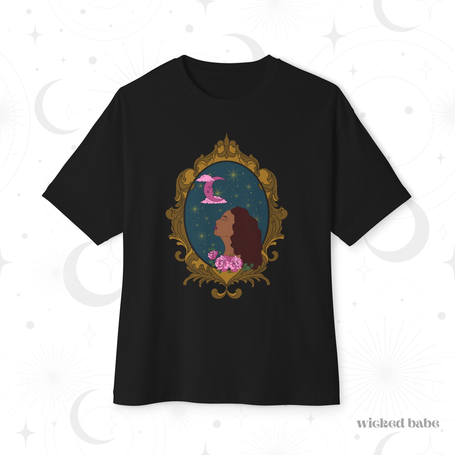 Oversized short sleeve black t-shirt with a design of a tan skinned woman with red brown wavy hair with pink flowers and a pink crescent moon above on a teal background surrounded by an ornate gold frame
