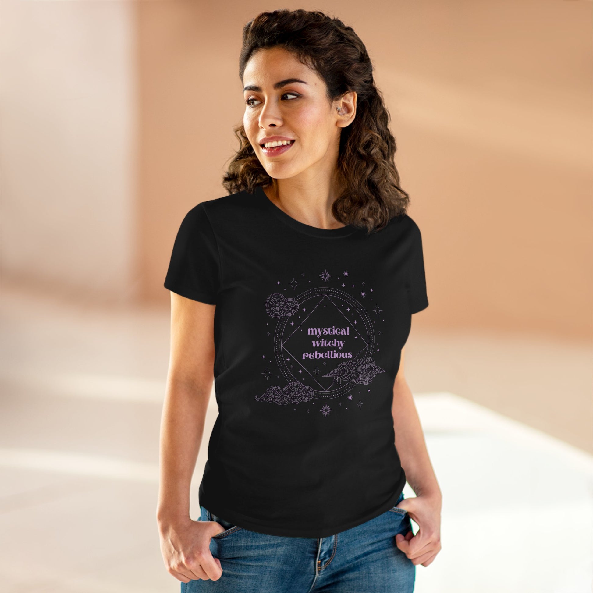 Woman wearing black short sleeve crewneck t-shirt with mystical witchy rebellious text in purple surrounded by clouds and stars